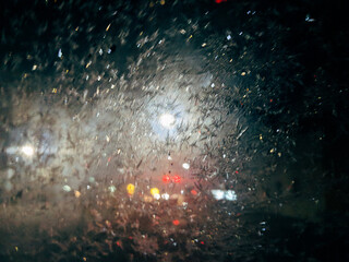 Rain drops on a glas panel with lights in the background