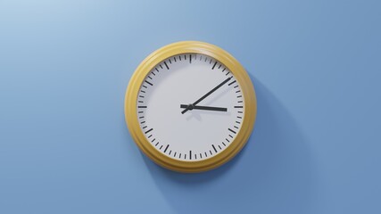 Glossy orange clock on a blue wall at nine past three. Time is 03:09 or 15:09