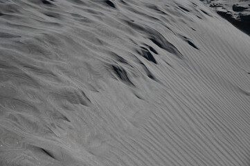 Abstraktes Muster und Skulpturen im Sand vom Wind geformt