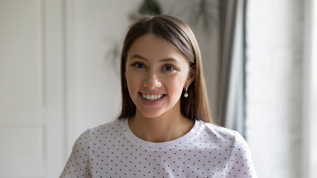 Profile picture of smiling millennial Caucasian girl look at camera posing at home, close up headshot portrait of happy young woman client show positivity satisfaction with good quality service