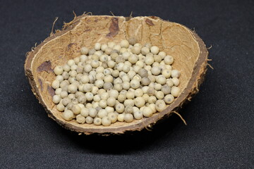 White pepper grains isolated on black background