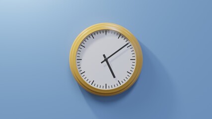 Glossy orange clock on a blue wall at nine past five. Time is 05:09 or 17:09