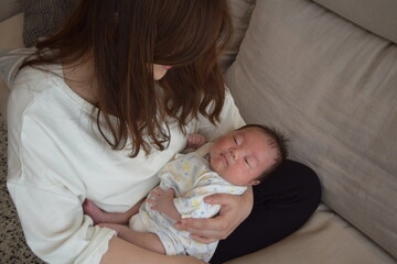 ママに抱かれて眠る生後36日の赤ちゃん
