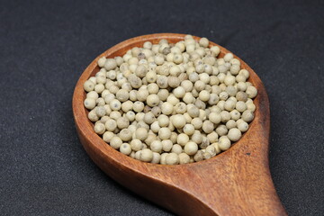 White pepper grains isolated on black background