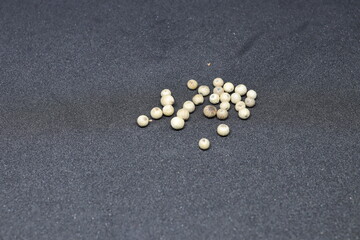 White pepper grains isolated on black background