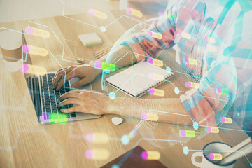 Multi exposure of world map hologram with man working on computer on background. Concept of worldwideweb.