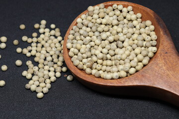 White pepper grains isolated on black background