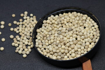 White pepper grains isolated on black background