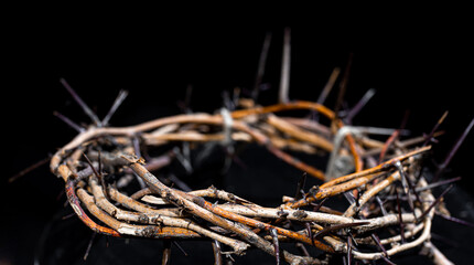 The crown of thorns lies on an isolated black background. The concept of Holy week, associated with suffering and love.