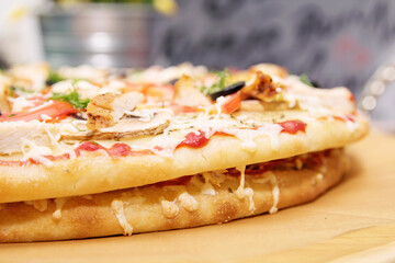 Ready-made pizza with filling on a wooden tray