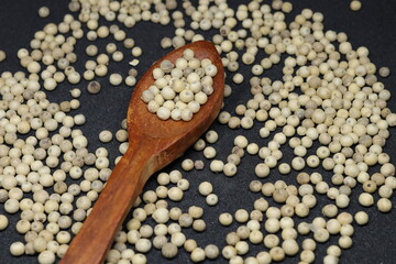White pepper grains isolated on black background