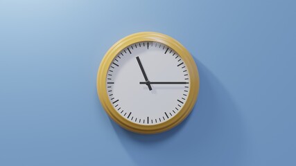 Glossy orange clock on a blue wall at quarter past eleven. Time is 11:15 or 23:15