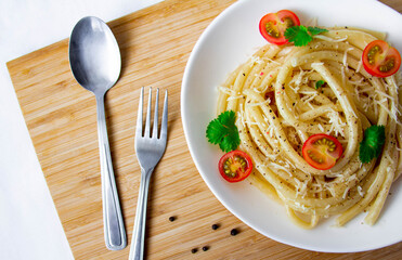 Spaghetti with cherry tomatoes and cheese on a wood board