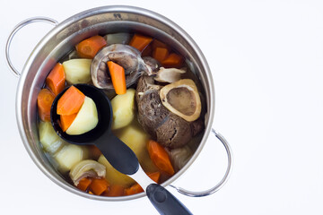 Beef marrow bone boiled in stainless steel pan with vegetables.The Sacrifice Festival Food preparation.