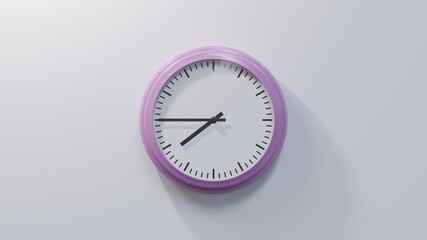 Glossy pink clock on a white wall at quarter to eight. Time is 07:45 or 19:45
