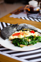 black pita on a white plate. Serving a Mediterranean breakfast. national street food. Fresh tasty ingredients.