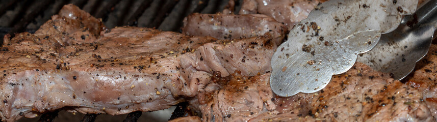 Beef steak being cooked on a South African Braai or Barbeque