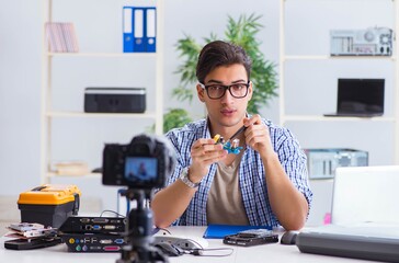 Vlogger recording computer repair on camera for vlog blog