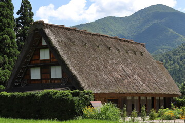 Fototapeta na wymiar 藁でできた大きな屋根の家