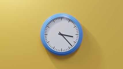 Glossy blue clock on a orange wall at twenty-three past three. Time is 03:23 or 15:23