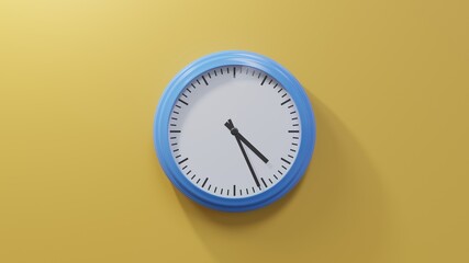 Glossy blue clock on a orange wall at twenty-six past four. Time is 04:26 or 16:26