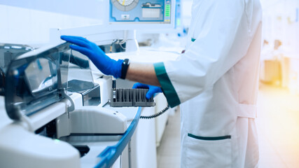 Fototapeta na wymiar Laboratory assistant in rubber gloves working with a modern immunochemistry analyzer