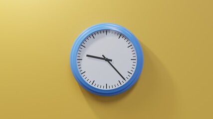 Glossy blue clock on a orange wall at twenty-three past nine. Time is 09:23 or 21:23