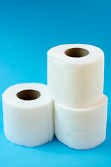 Three rolls of white toilet paper on a blue background