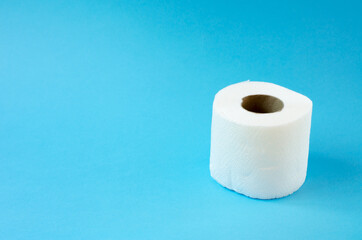 Roll of white toilet paper on a blue background horizontal photo. Personal hygiene products.