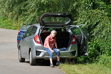 seniorin sitzt in offenem auto