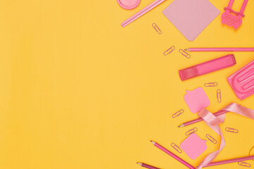 Minimalism, Back to school concept, Pink school supplies on yellow background, flat lay with copy space