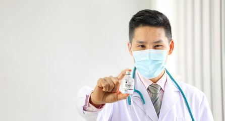 Naklejka premium Asian male doctor holding newly discover approved vaccine from laboratory in bottle with copy space