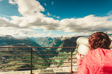 Fototapeta na wymiar Tourist looking through binoculars in mountains, Norway