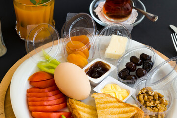 Traditional Turkish Breakfast Plate with boiled egg,orange juice and tea on black surface.Top view