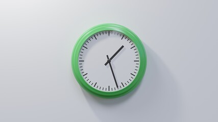 Glossy green clock on a white wall at twenty-seven past one. Time is 01:27 or 13:27