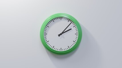 Glossy green clock on a white wall at seven past two. Time is 02:07 or 14:07