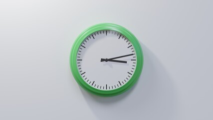 Glossy green clock on a white wall at thirteen past three. Time is 03:13 or 15:13