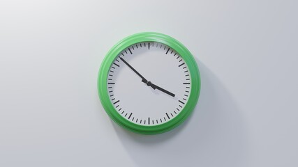 Glossy green clock on a white wall at fifty-two past three. Time is 03:52 or 15:52