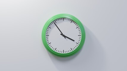 Glossy green clock on a white wall at fifty-four past three. Time is 03:54 or 15:54