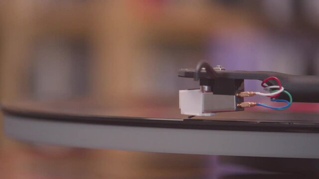 Spinning and lifting stylus off of an black vinyl lp extreme close up