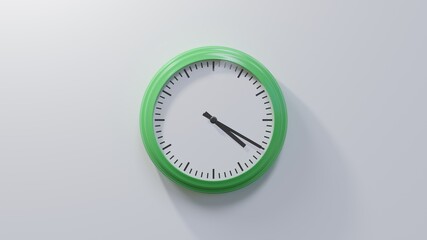 Glossy green clock on a white wall at twenty past four. Time is 04:20 or 16:20
