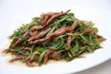 Close up view of  typical Chinese Szechuan cuisine Fried Shredded Pork with green Bell Peppers