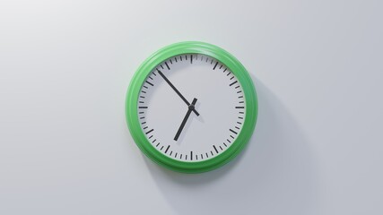 Glossy green clock on a white wall at fifty-three past six. Time is 06:53 or 18:53