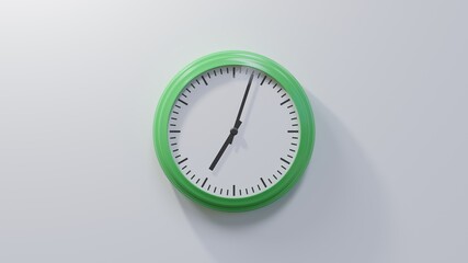 Glossy green clock on a white wall at three past seven. Time is 07:03 or 19:03