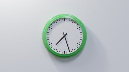 Glossy green clock on a white wall at twenty-seven past seven. Time is 07:27 or 19:27