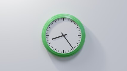 Glossy green clock on a white wall at twenty-four past eight. Time is 08:24 or 20:24