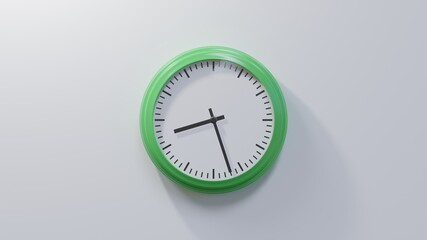 Glossy green clock on a white wall at twenty-seven past eight. Time is 08:27 or 20:27