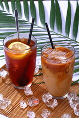 Close up of glass of Iced Lemon tea and Hong Kong style milk tea with ice cube