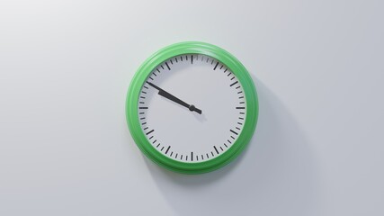 Glossy green clock on a white wall at ten to ten. Time is 09:50 or 21:50