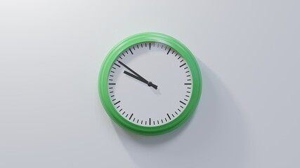 Glossy green clock on a white wall at fifty-one past nine. Time is 09:51 or 21:51